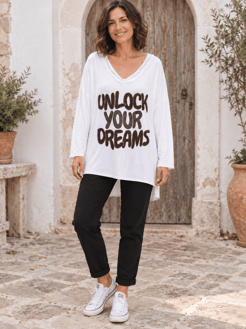 Tunique blanche Unlock Your Dreams portée avec un pantalon noir, devant simple et pan arrière plus long.
