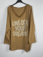 Tunique camel sur cintre, manches longues et message clair Unlock Your Dreams.