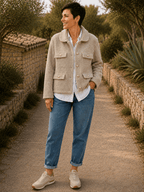 Veste Giulia bouclée beige grège portée par Sofia avec chemise blanche et jean dans un décor d’automne