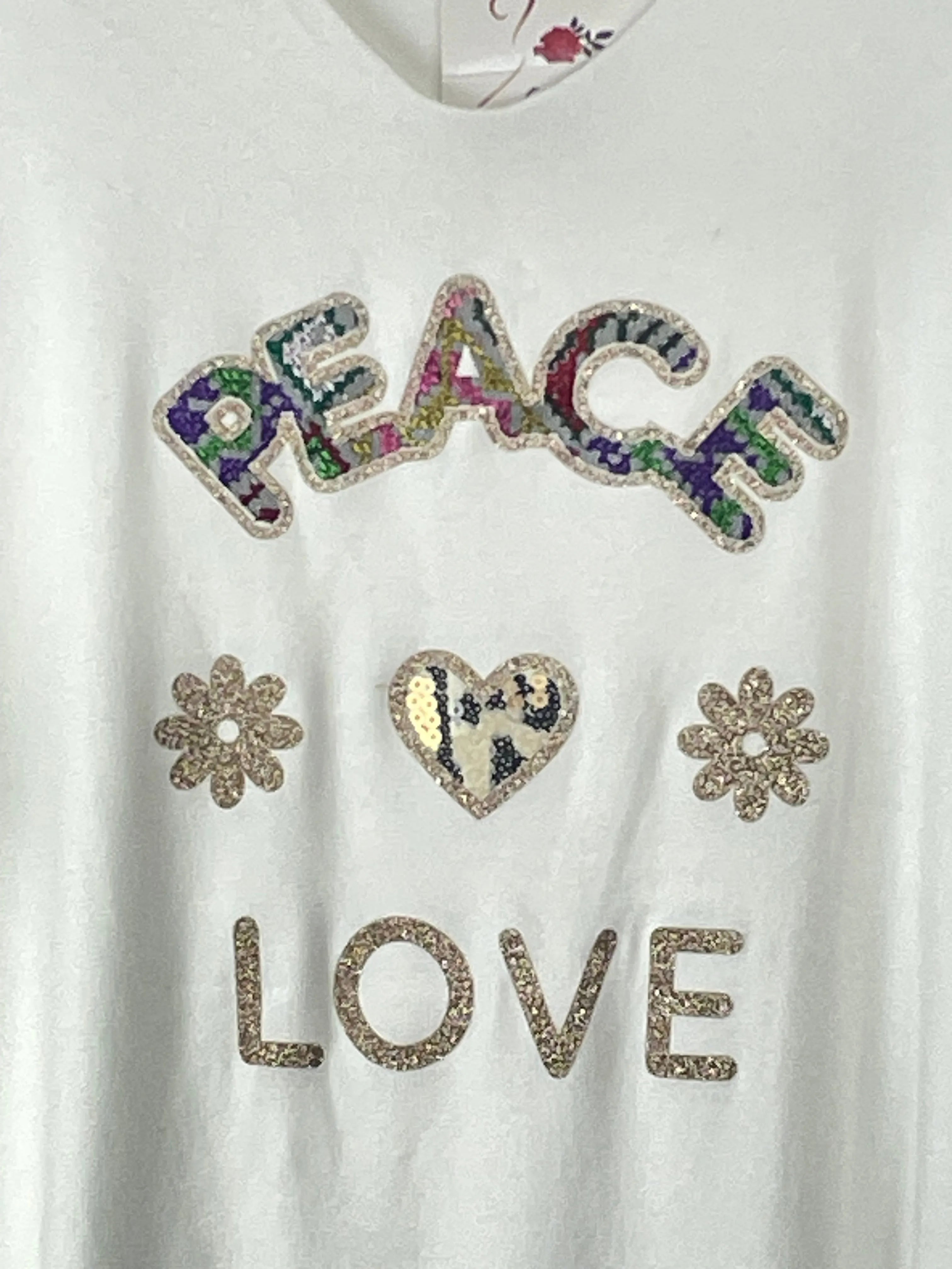 Détail du motif sequins Peace & Love sur pull oversize blanc