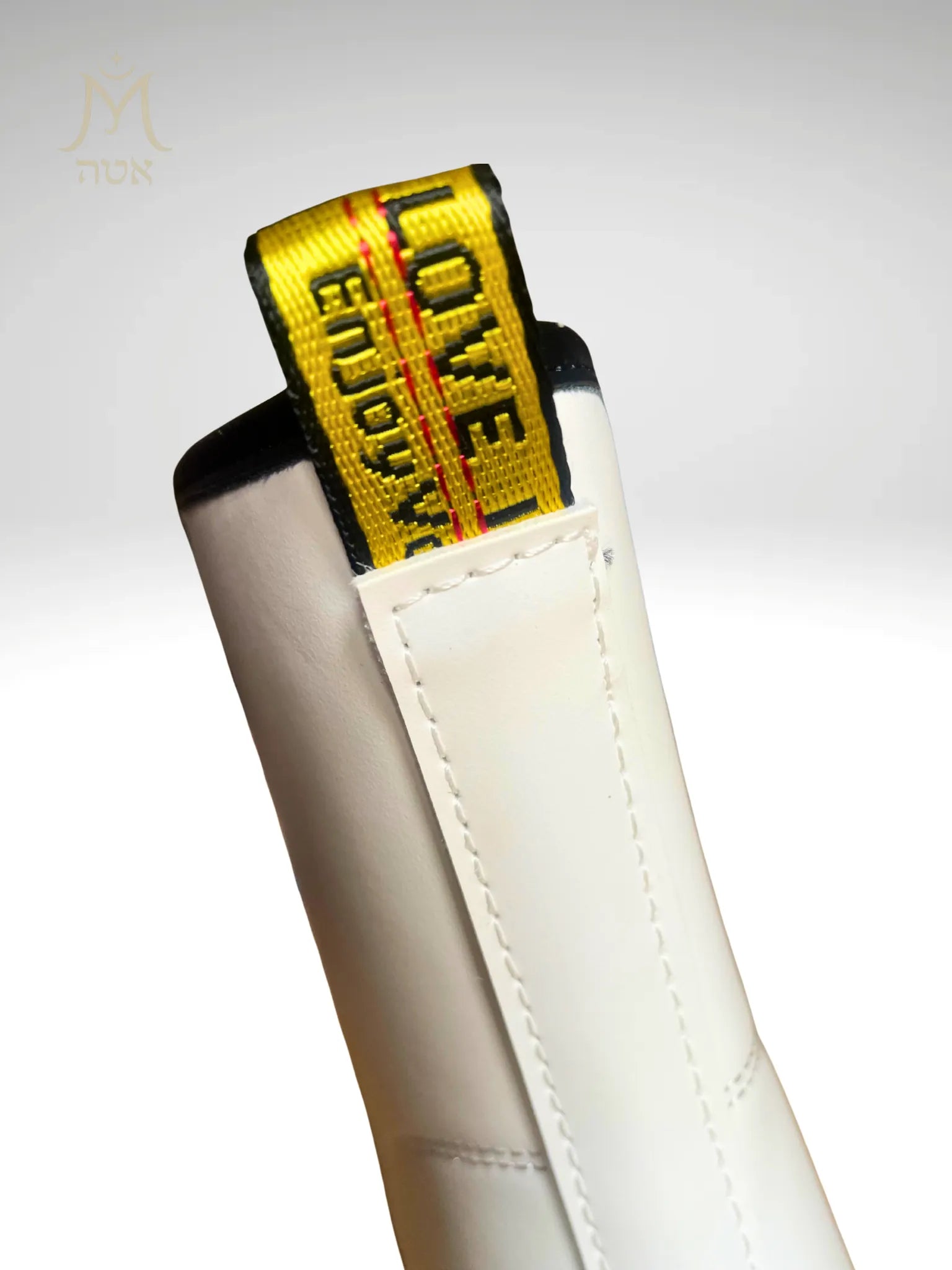 détail languette jaune Love Enjoy à l’arrière de la bottine blanche